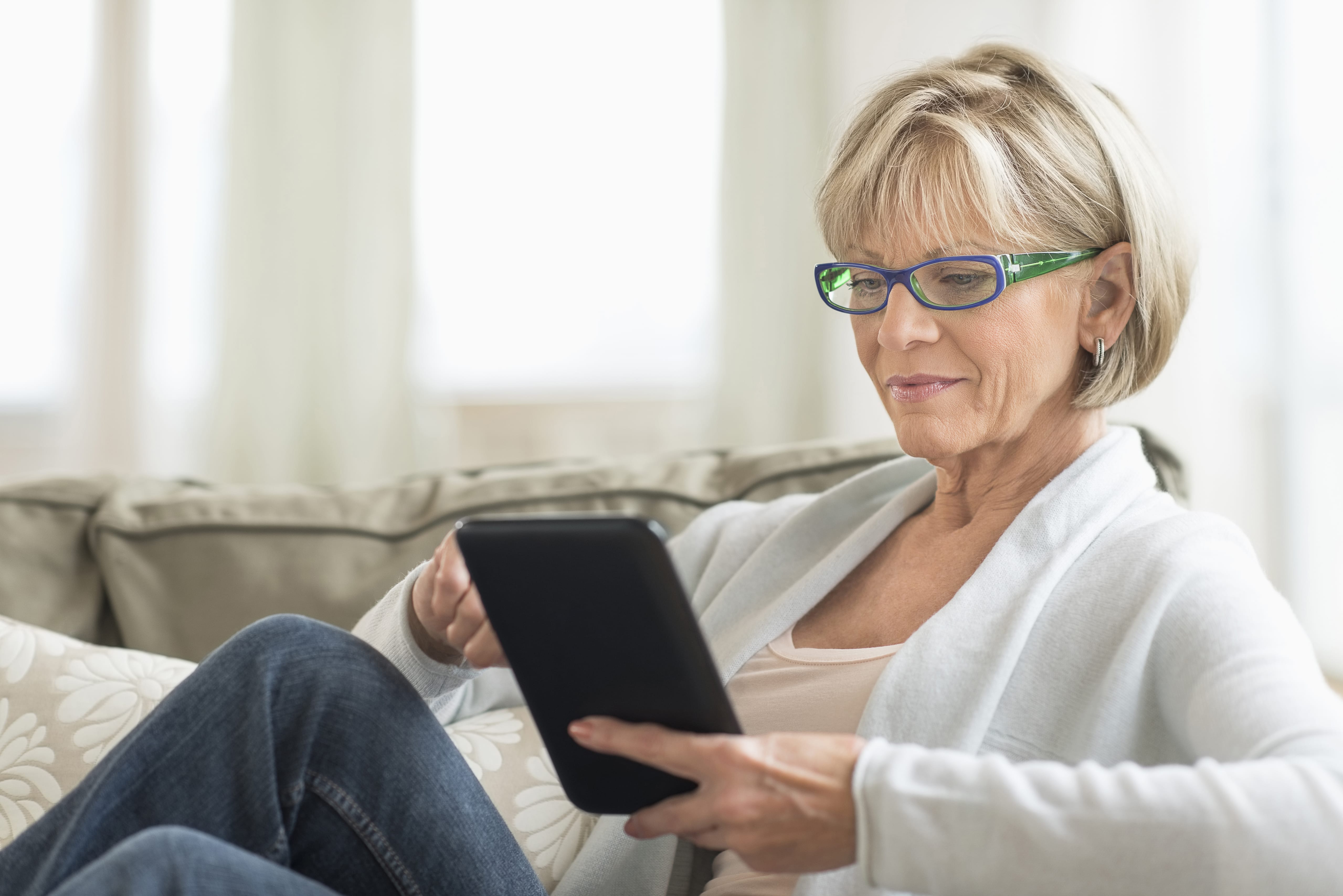 Woman sitting down looking at her tablet